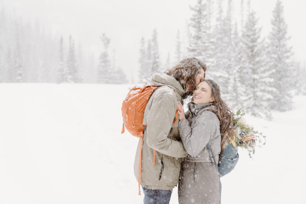 A coupe eloping in Rocky Mountain National Park during a winter snowstorm