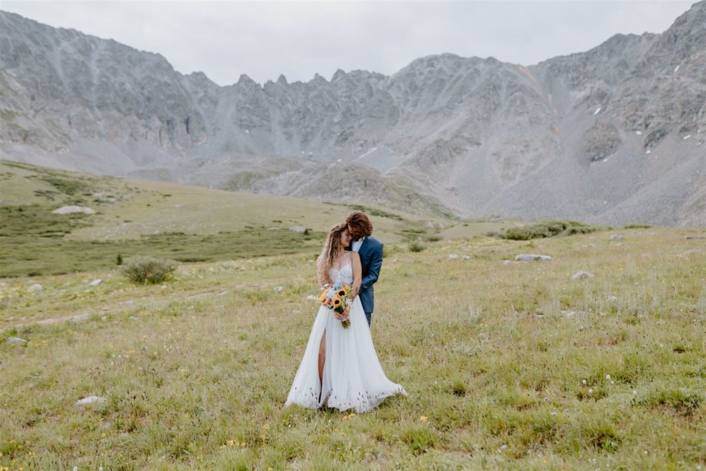 couple standing romantically in meadow