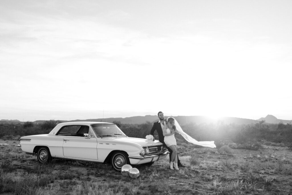 couple leaning on classic car during Arizona elopement