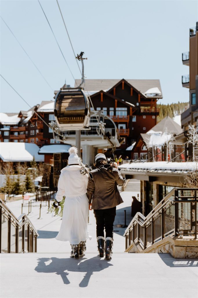 couple walking with ski gear down to ski lift