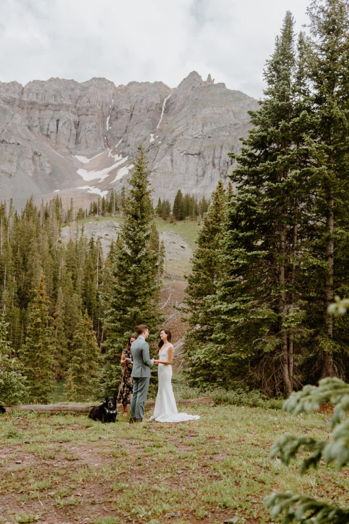 couple saying their vows under mountain 