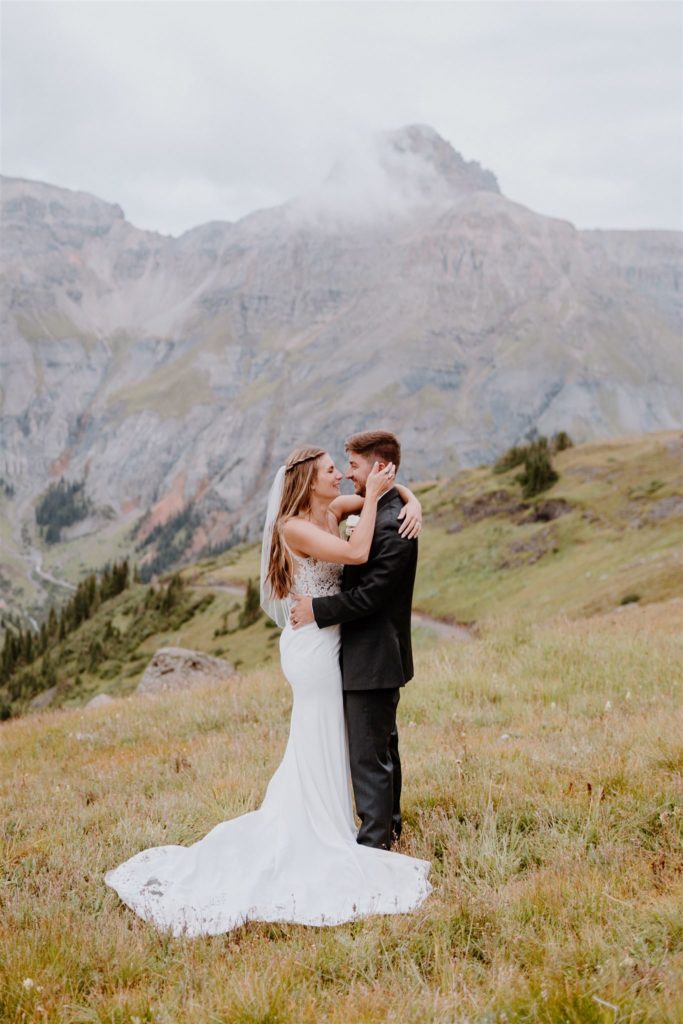 couple standing while hugging on mountain side
