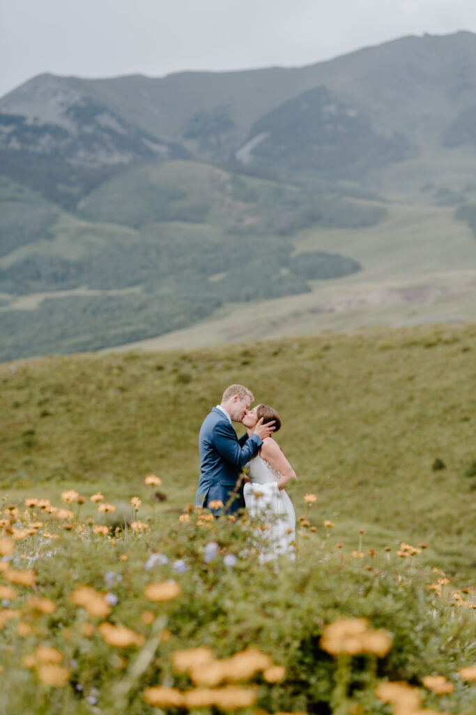couple kissing in wildflower field