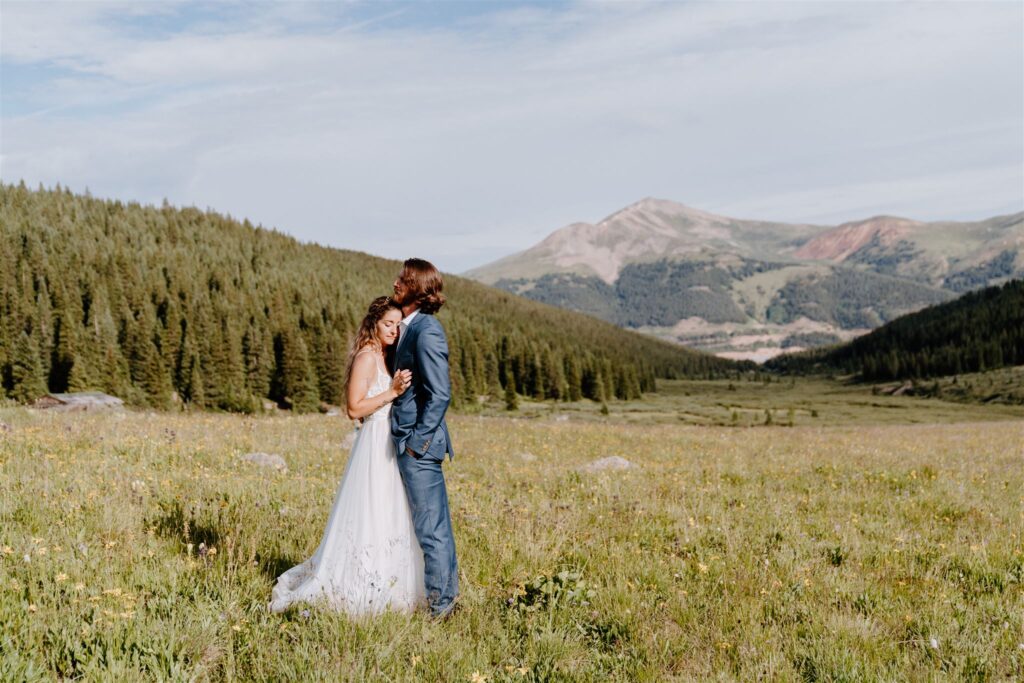 man and woman standing in meadow in colorado