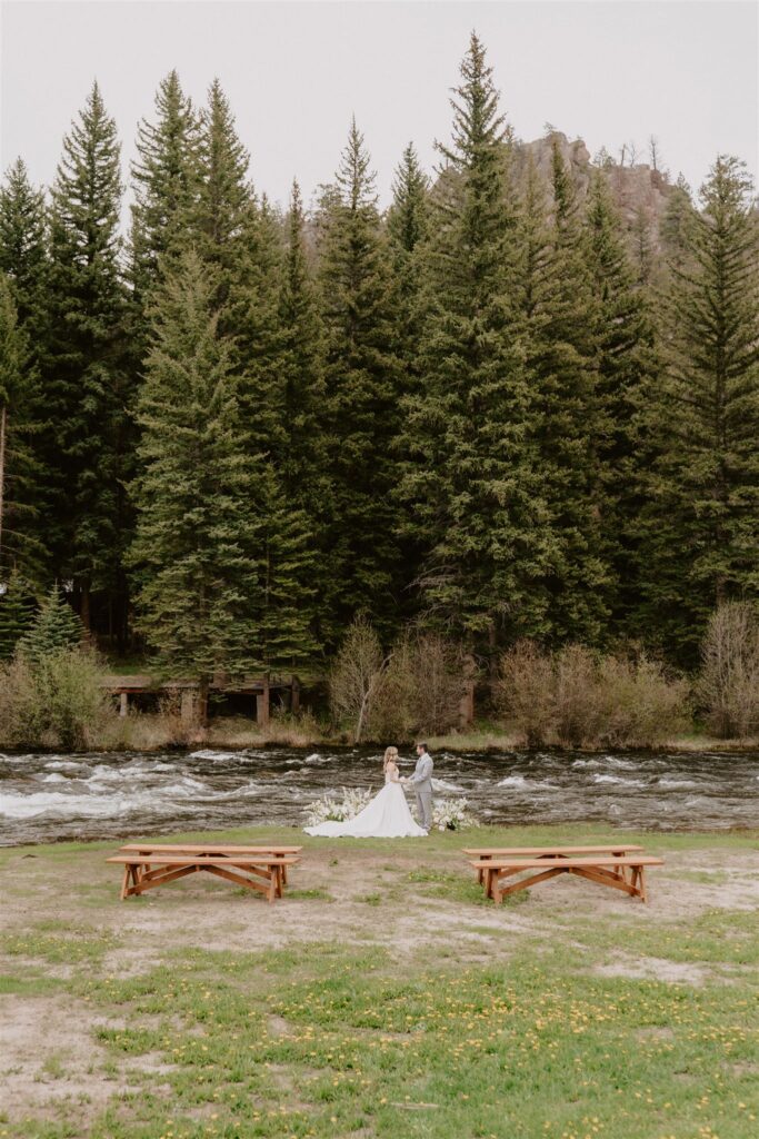 couple reading vows by a creek