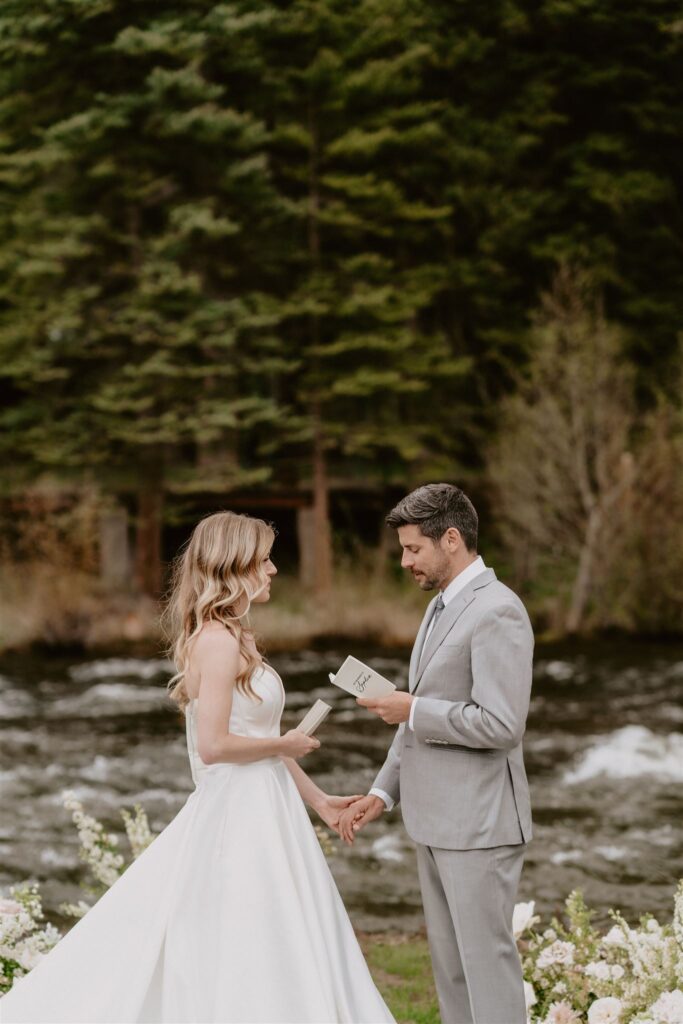 couple reading vows by a creek