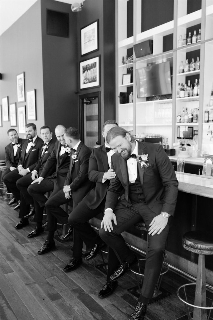 groom and groomsmen sit in the Surf Hotel and Chateau 