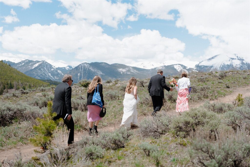 Bride and family walk up to mountainous elopement location