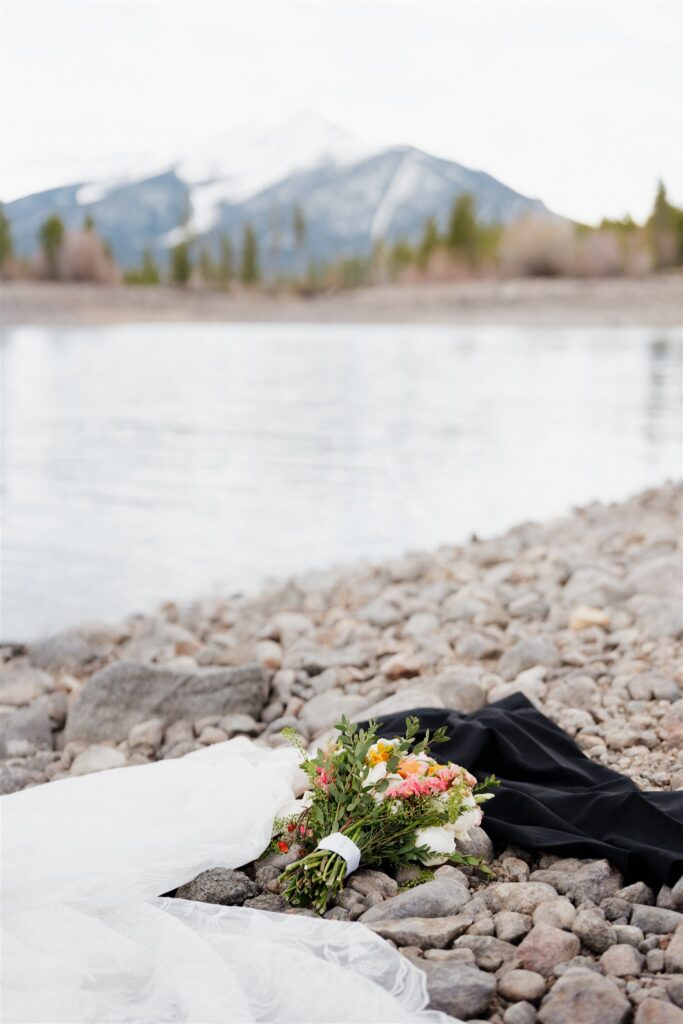 Bride and grooms clothes lay on the shore as they skinny dip