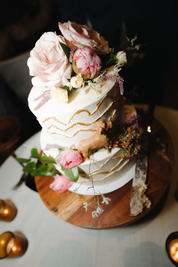 Wedding cake featuring a little dog figuring to represent their dog, Piper.