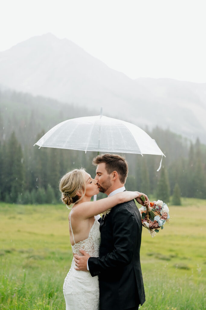 Bride and groom photos in the rain with a clear umbrella