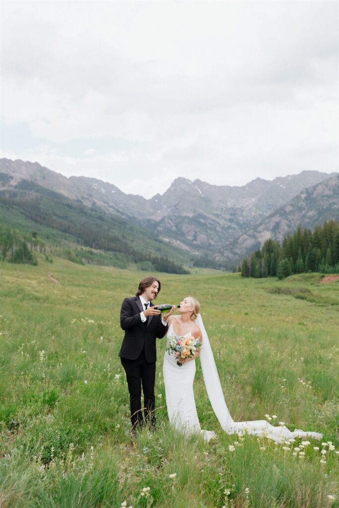 Bride and groom pop champagne during their Colorado micro wedding