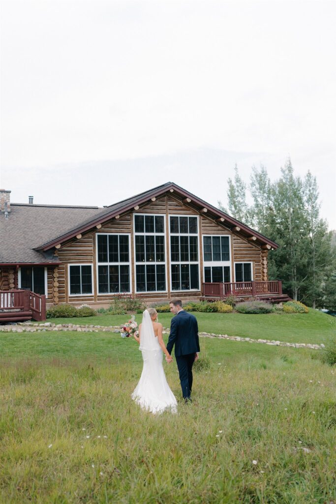 Bride and groom walk balk to Beano's Cabin after wedding portraits in the Colorado mountains