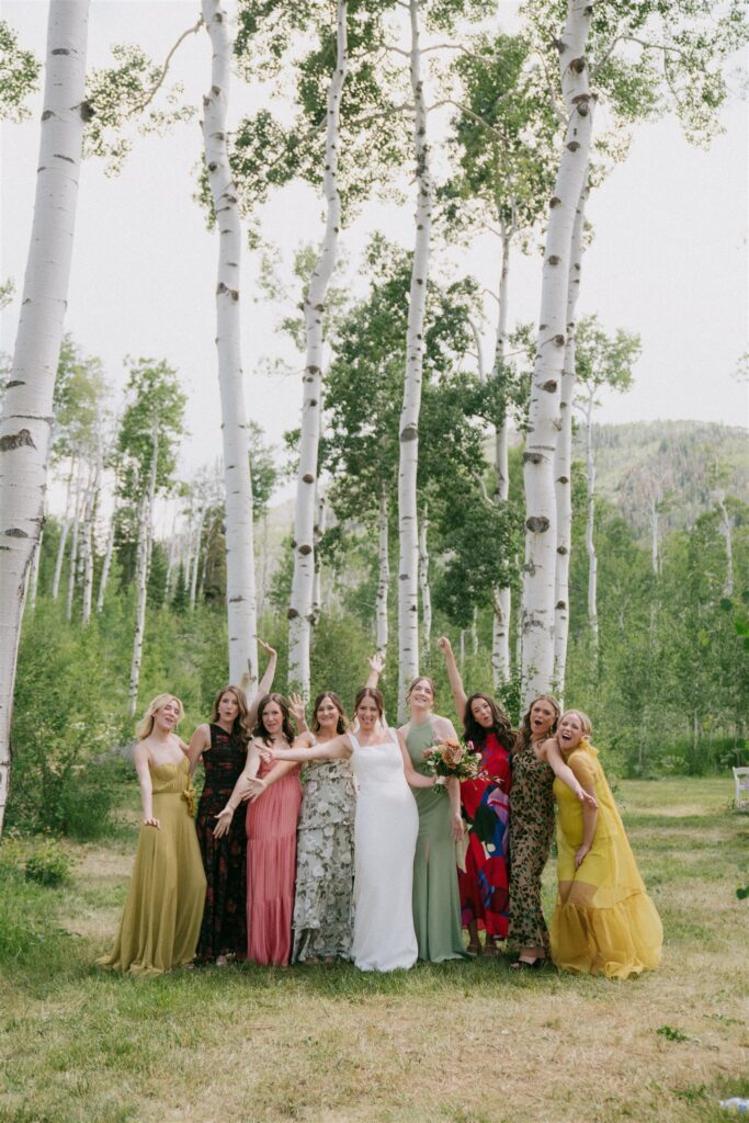 Bride stands with her bridesmaids as they wear funky retro bridesmaid dresses