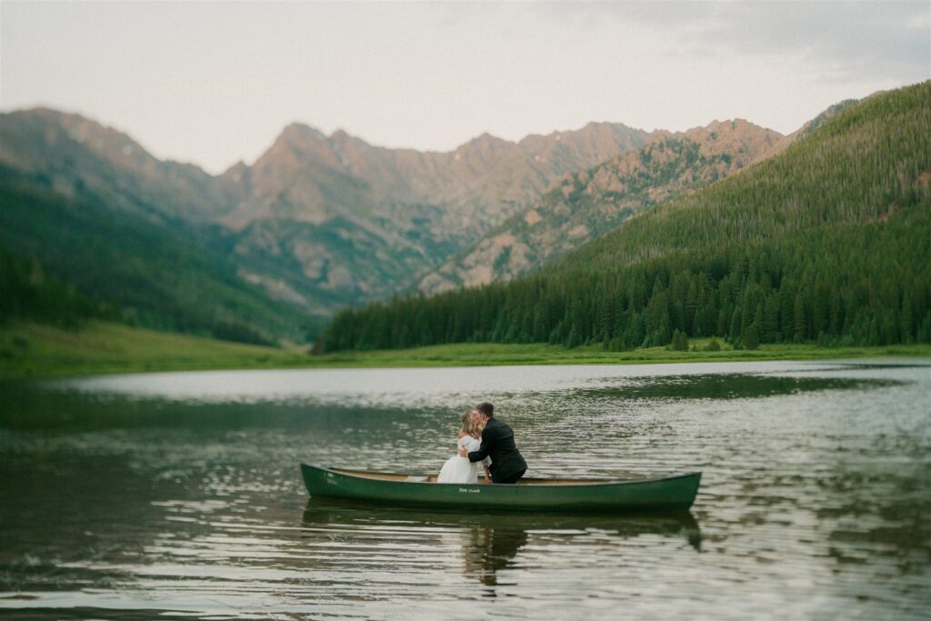 Bride and groom kiss in a canoe on Piney Lake