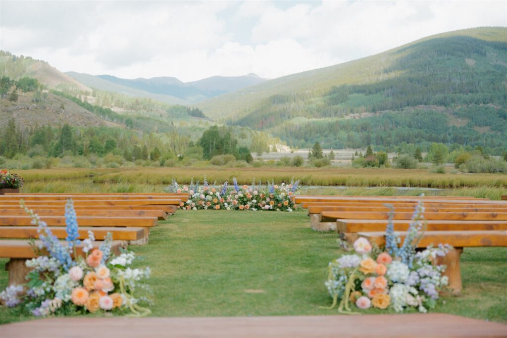 Camp Hale wedding ceremony setup with colorful florals and mountain views