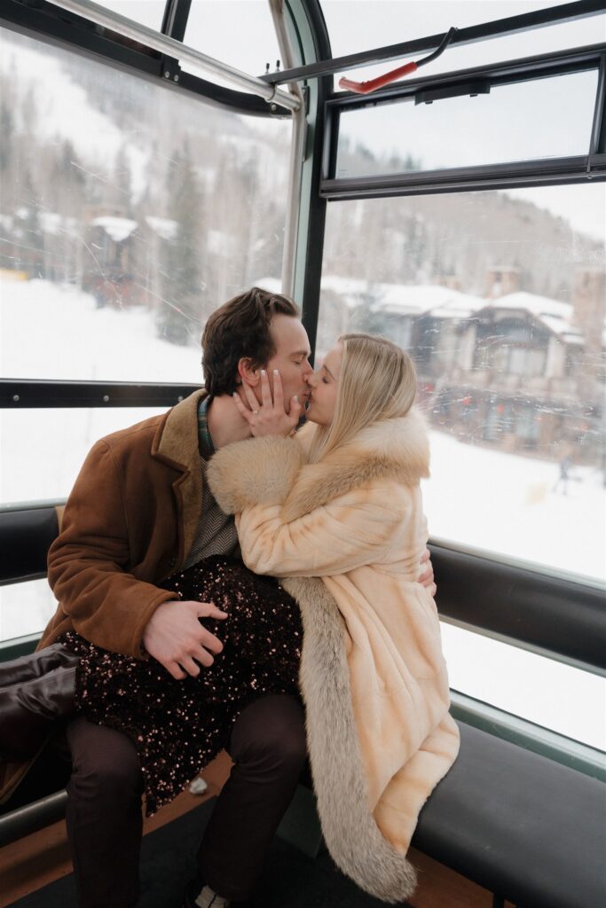 Couple rides the gondola down Vail Mountain during their winter engagement session