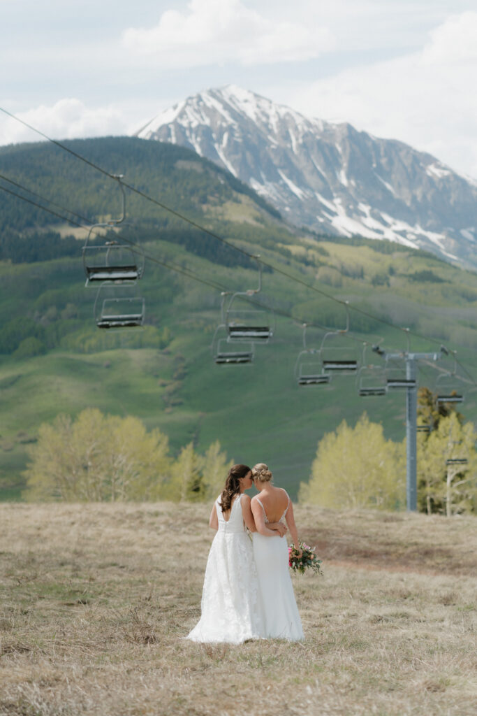 Spring wedding in Crested Butte, brides under ski lift on wedding day
