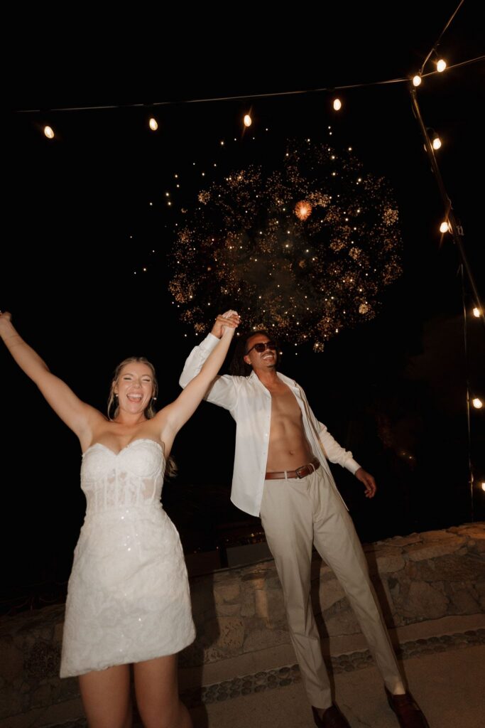 Bride and groom celebrate with fireworks in the backdrop