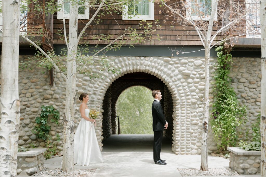 Bride and groom first look in front of a stone arch at the Surf Hotel in Buena Vista
