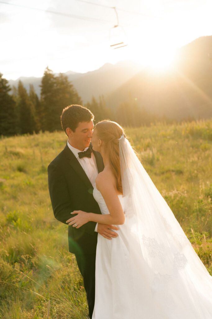 Bride and groom stand in a mountain meadow in Crested Butte Colorado during sunset