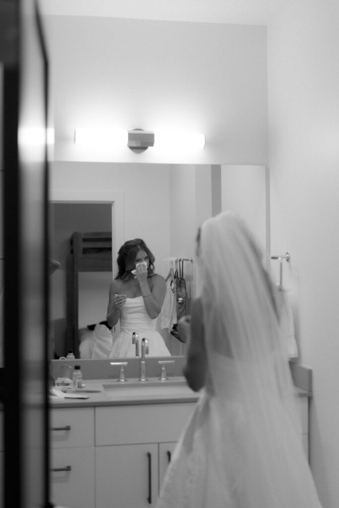 Bride wipes tears away in the restroom before her mountaintop wedding ceremony