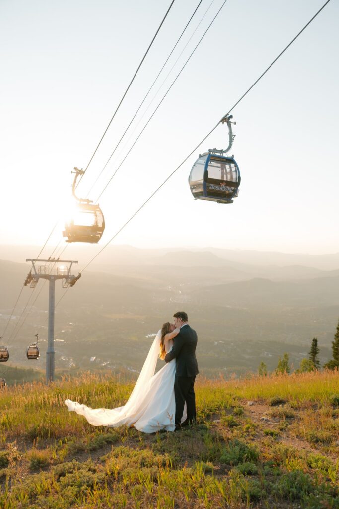 Mountaintop wedding portraits at sunset at Steamboat Resort with gondolas riding overhead